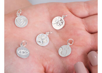 Mão feminina segurando medalinhas de pingente de Prata 925