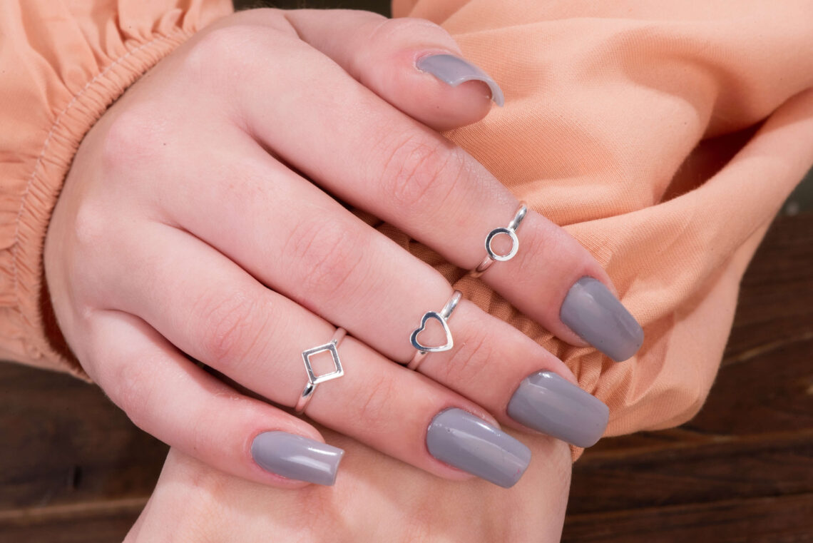 Mãos femininas com anéis falange em prata nos dedos