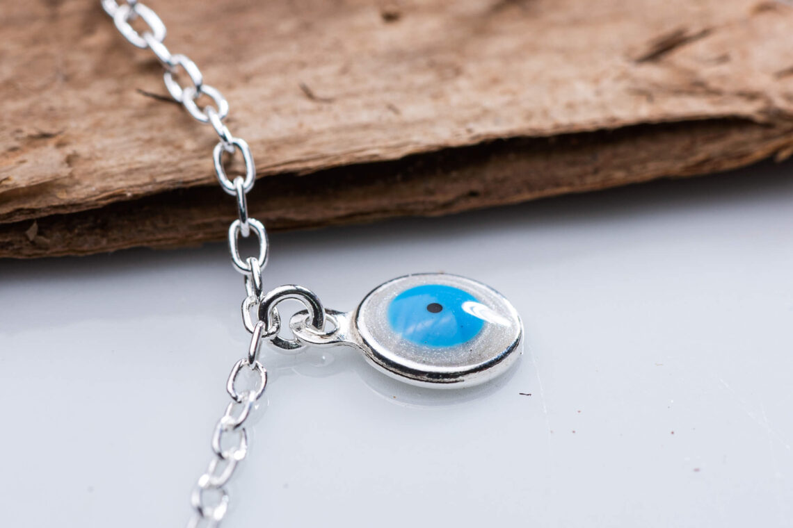 Pingente em prata 925 feito de resina sintética com o formato de olho grego.