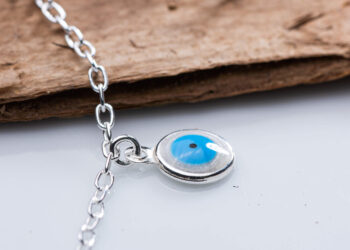 Pingente em prata 925 feito de resina sintética com o formato de olho grego.