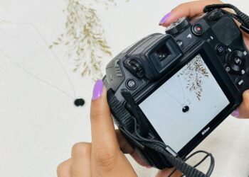 Visão de uma câmera fotográfica profissional fazendo fotos de uma gargantilha prata 925.