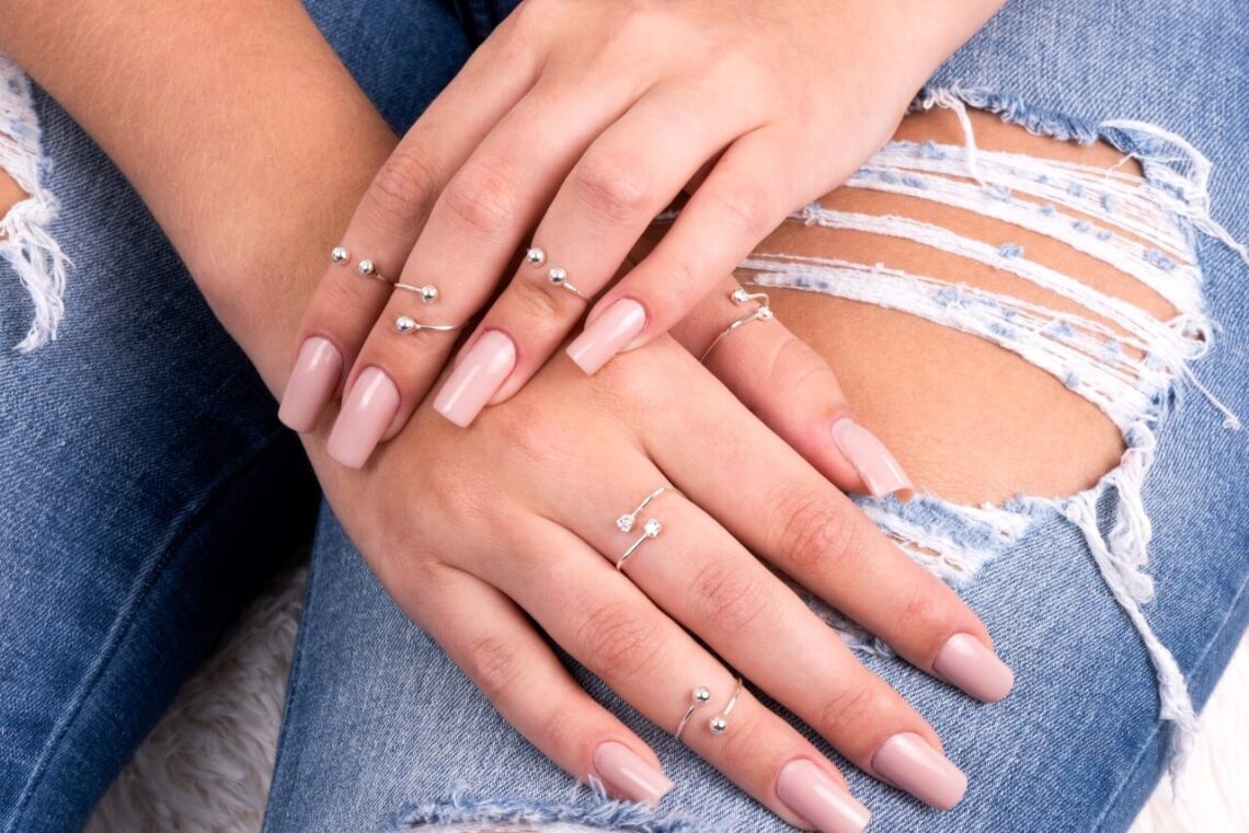 Mãos femininas com diversos modelos de anel de falange.