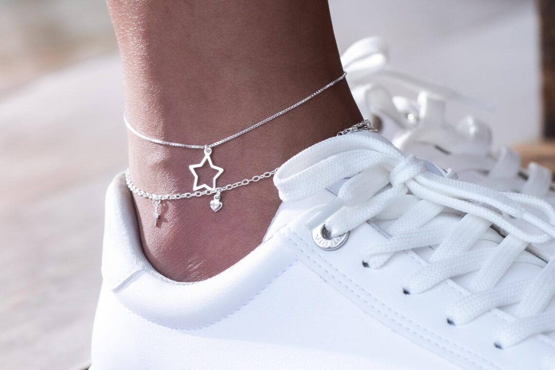 Modelo usando tênis branco e tornozeleira prata 925
